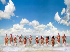 Dames met kerstmutsen komen uit het water
