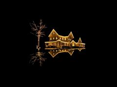 Een huis in het donker verlicht met kerstverlichting
